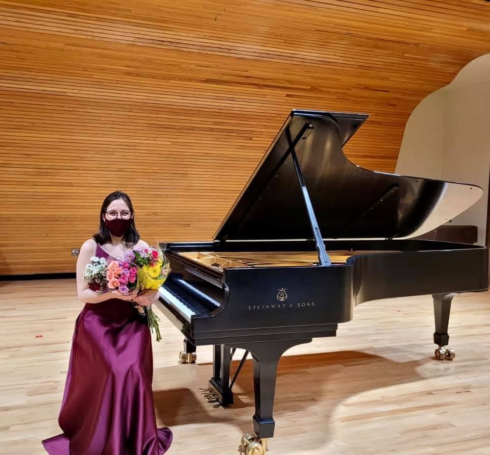 Gloria Lemus beside a Steinway concert grand piano after a recital